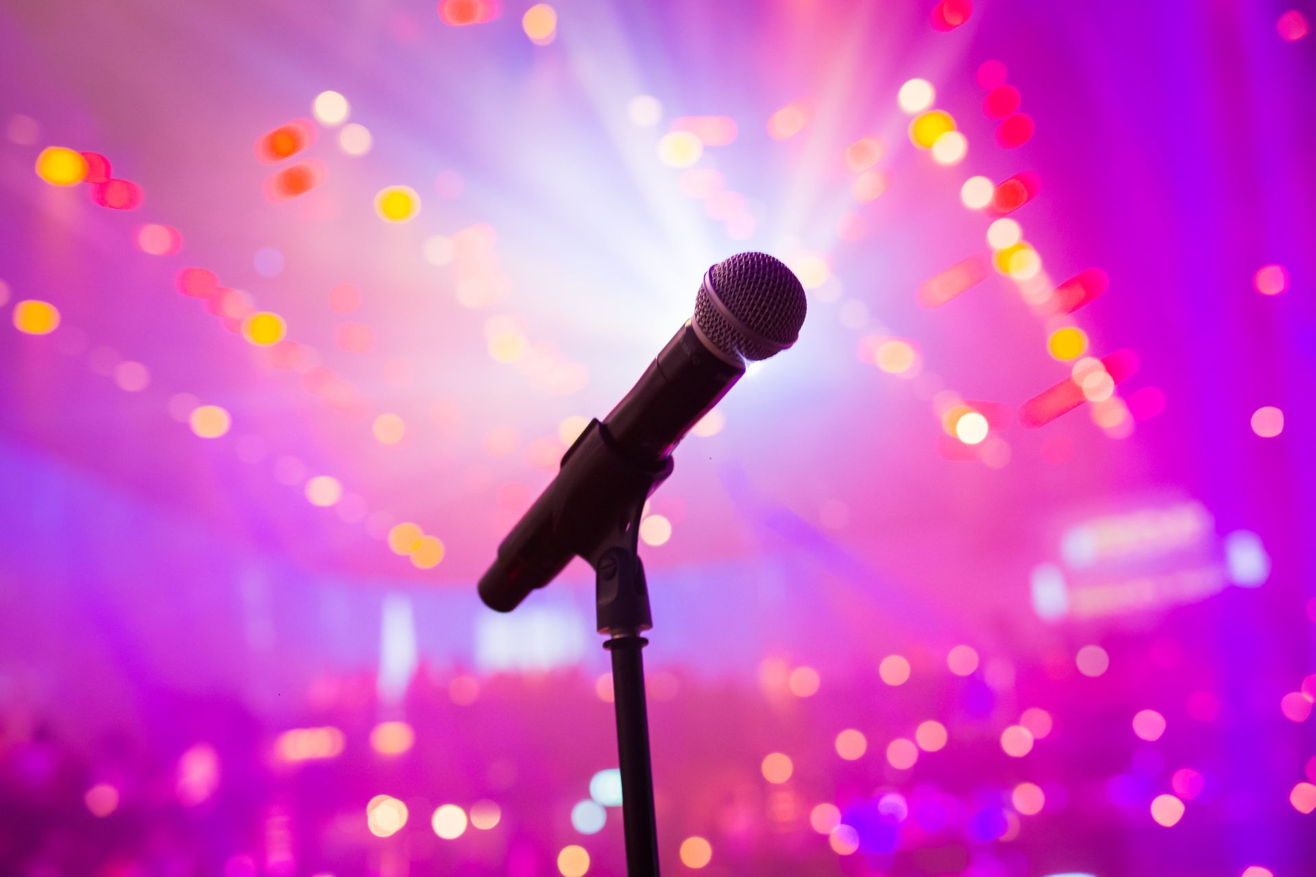 Selective Focus Photo of a Microphone Near Pink Lights